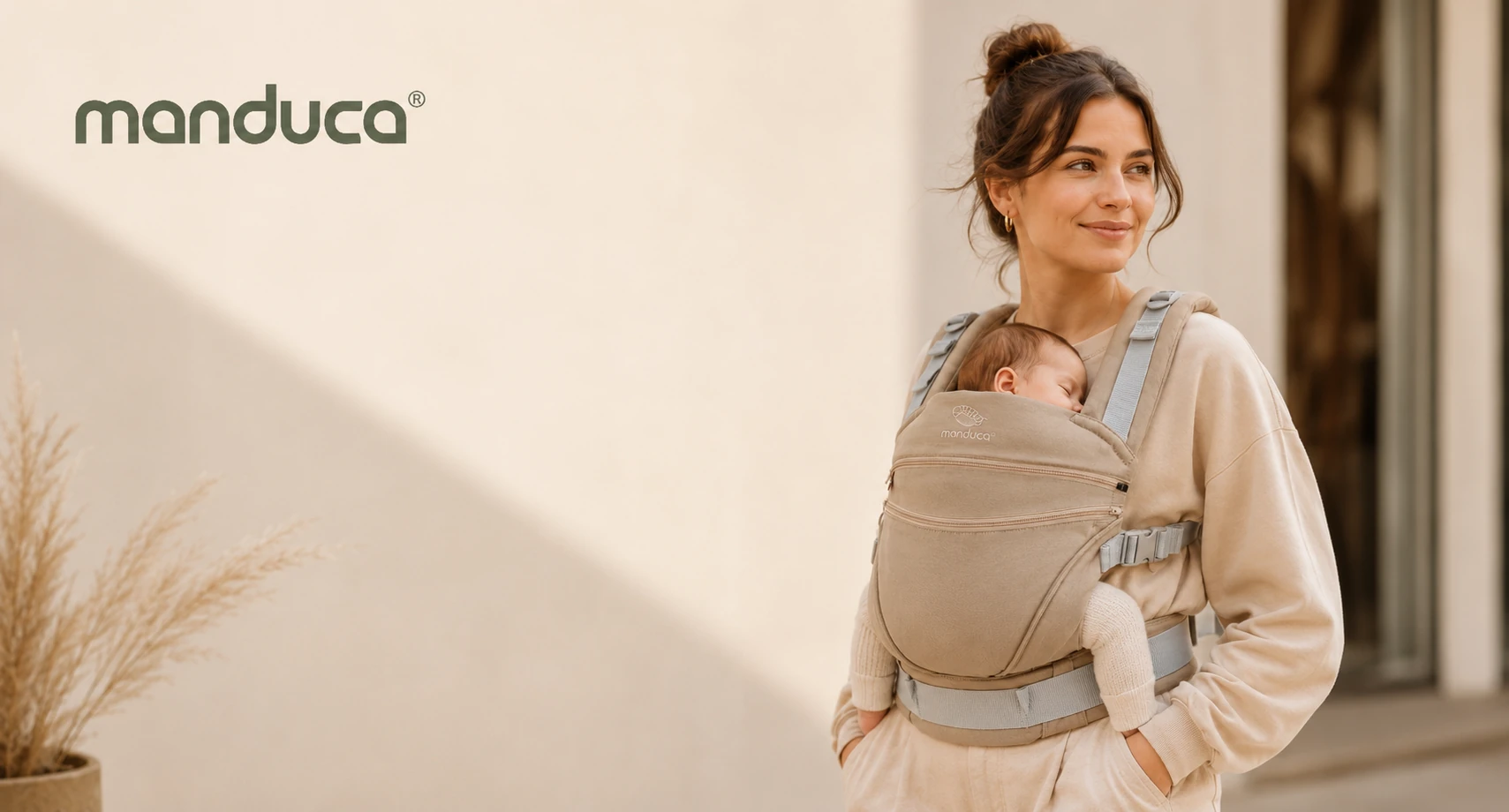 Mutter trägt baby in der manduca XT Monochrome Nougat , mit dem manduca logo im Bild