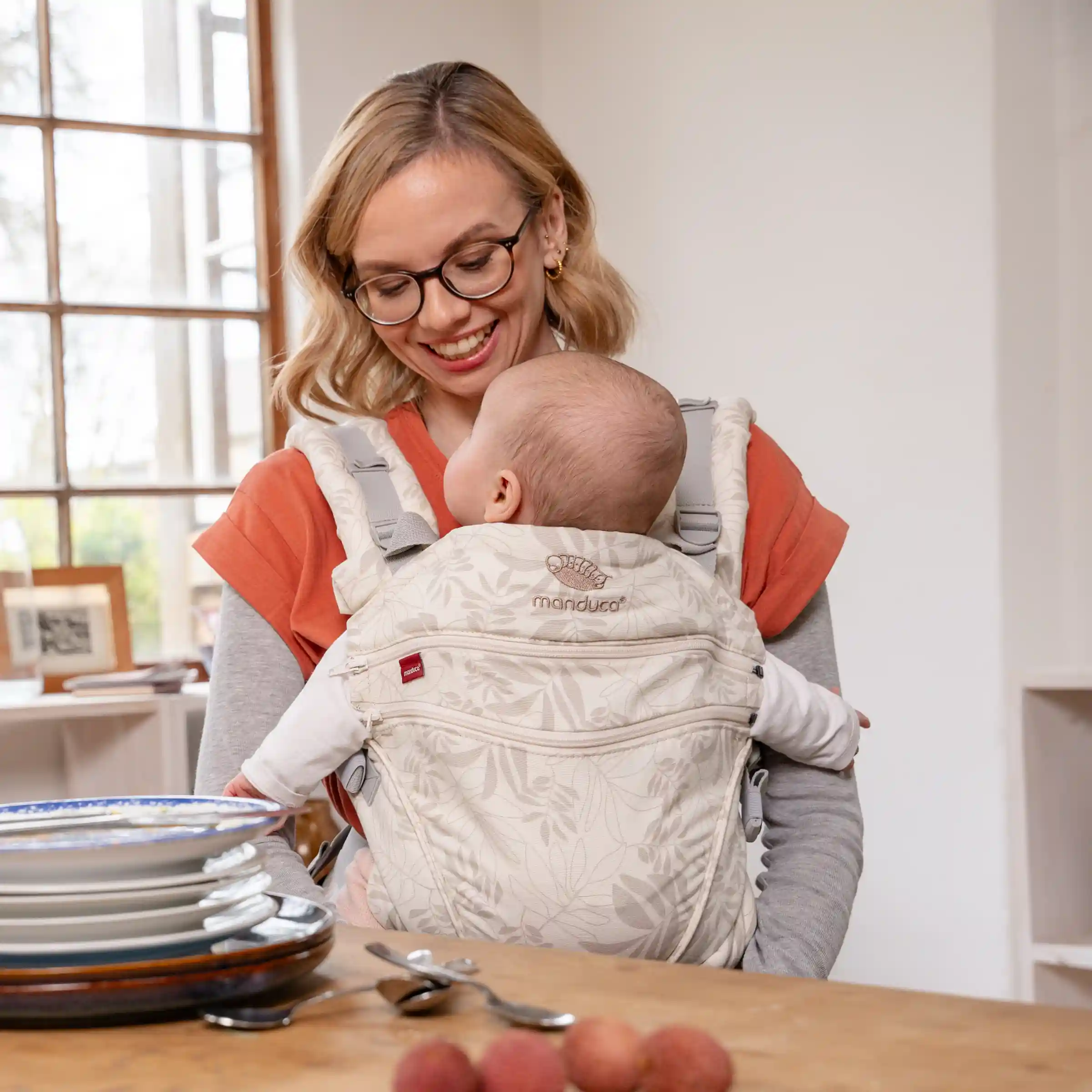 Mutter trägt Baby in der manduca XT Botanic Vanilla Babytrage