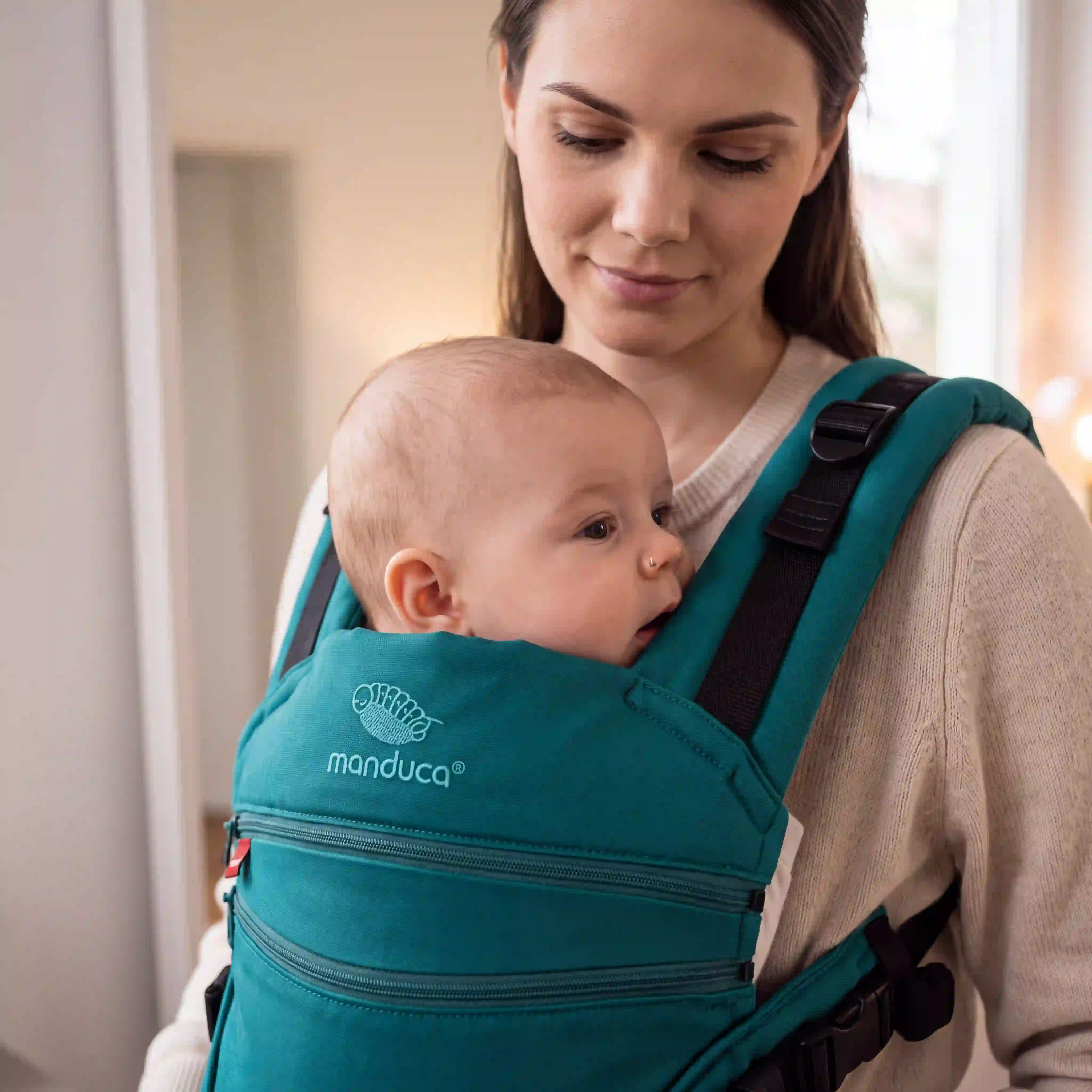 Baby mit gut sichtbarem Gesicht und freien Atemwegen in einer manduca Babytrage