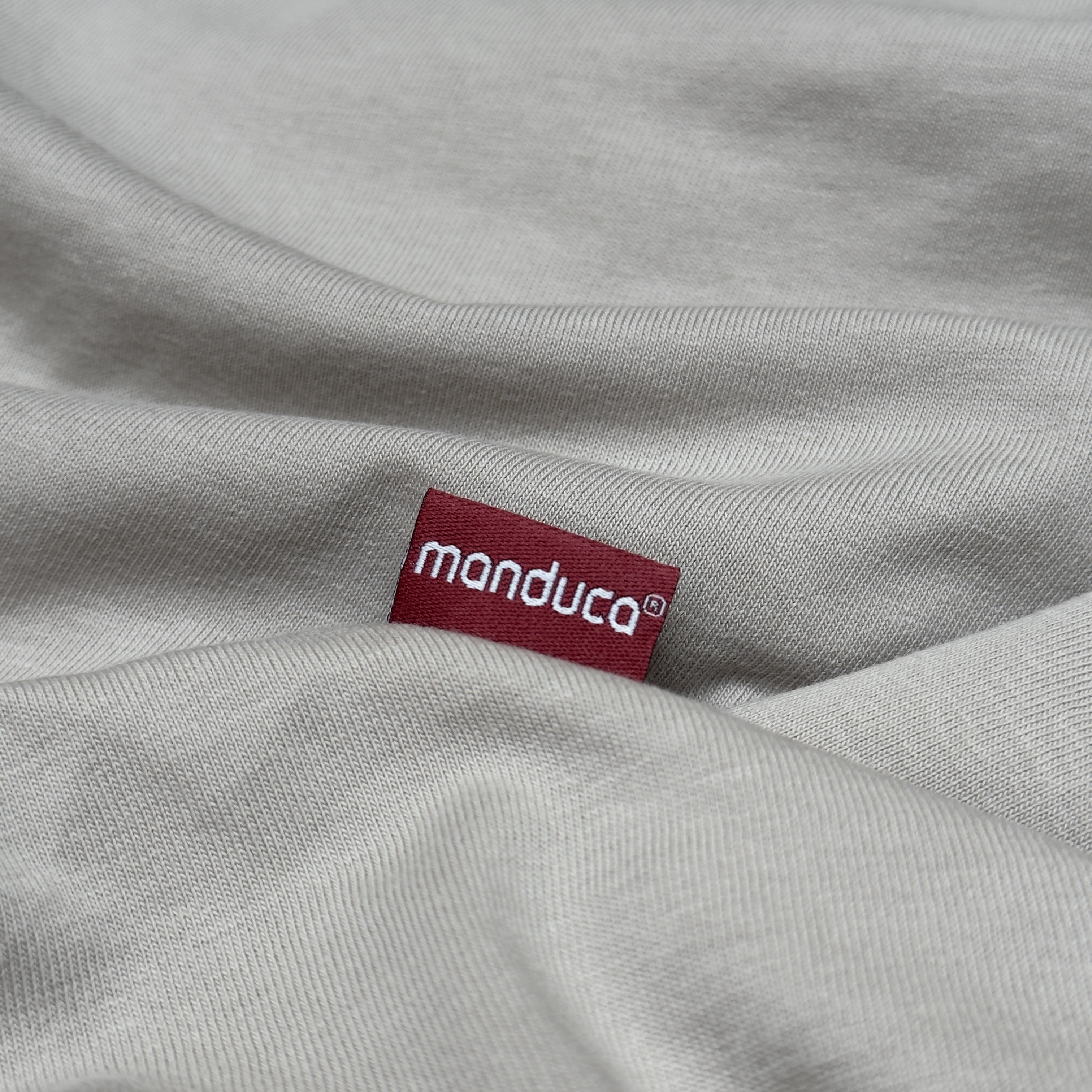 manduca CoPillow Stillkissen Soft Ivory mit Logo im Stoffdetail