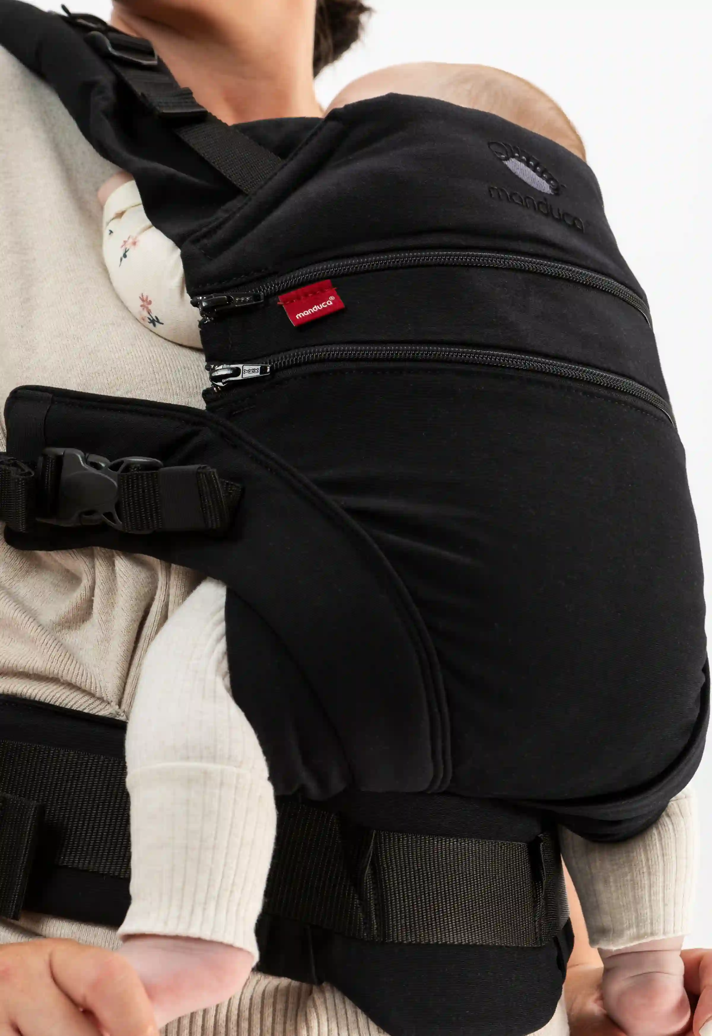 Nahaufnahme von manduca Babytrage in Schwarz mit einem Baby in der M-Position