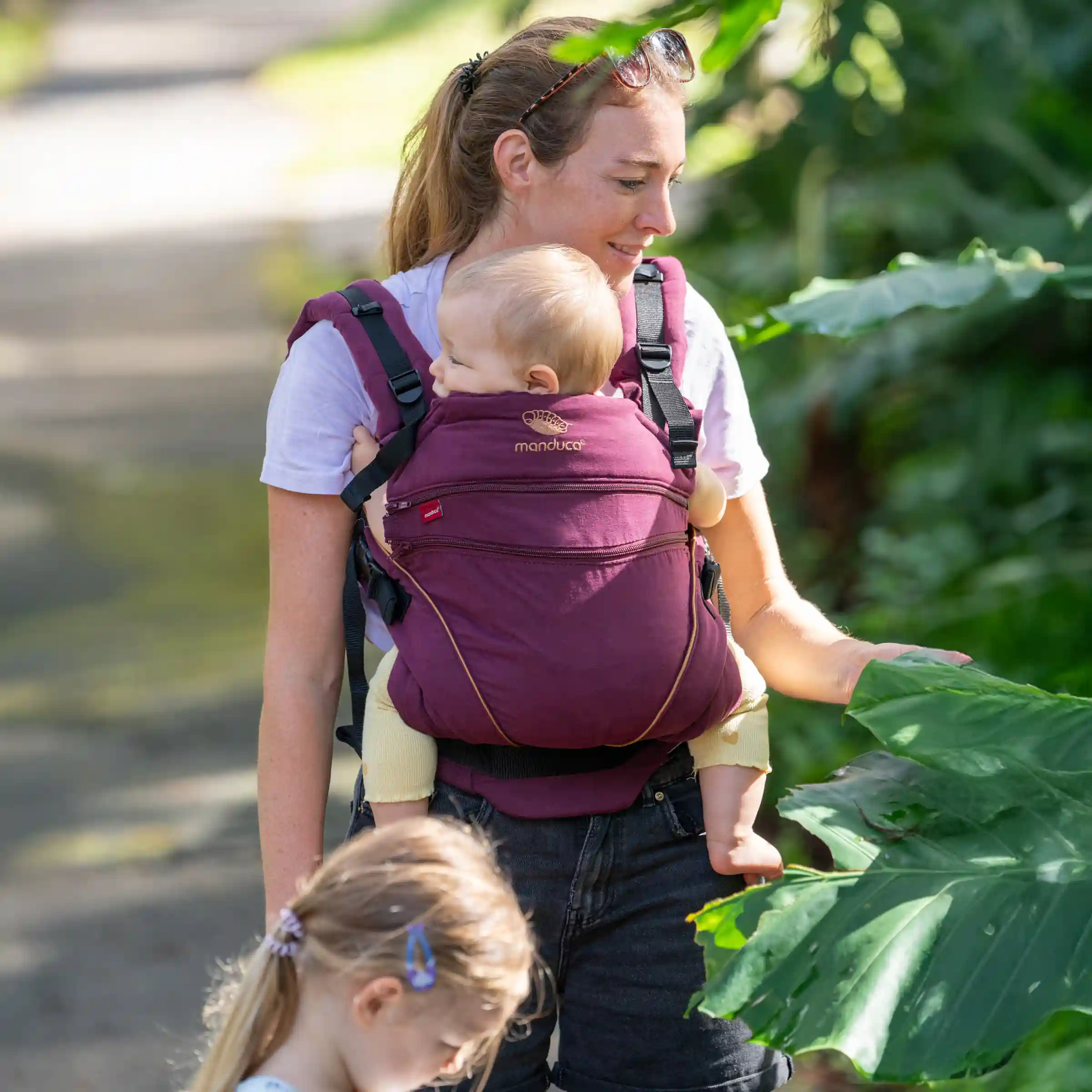 Elternteil trägt Baby beim Spaziergang, beide wirken entspannt