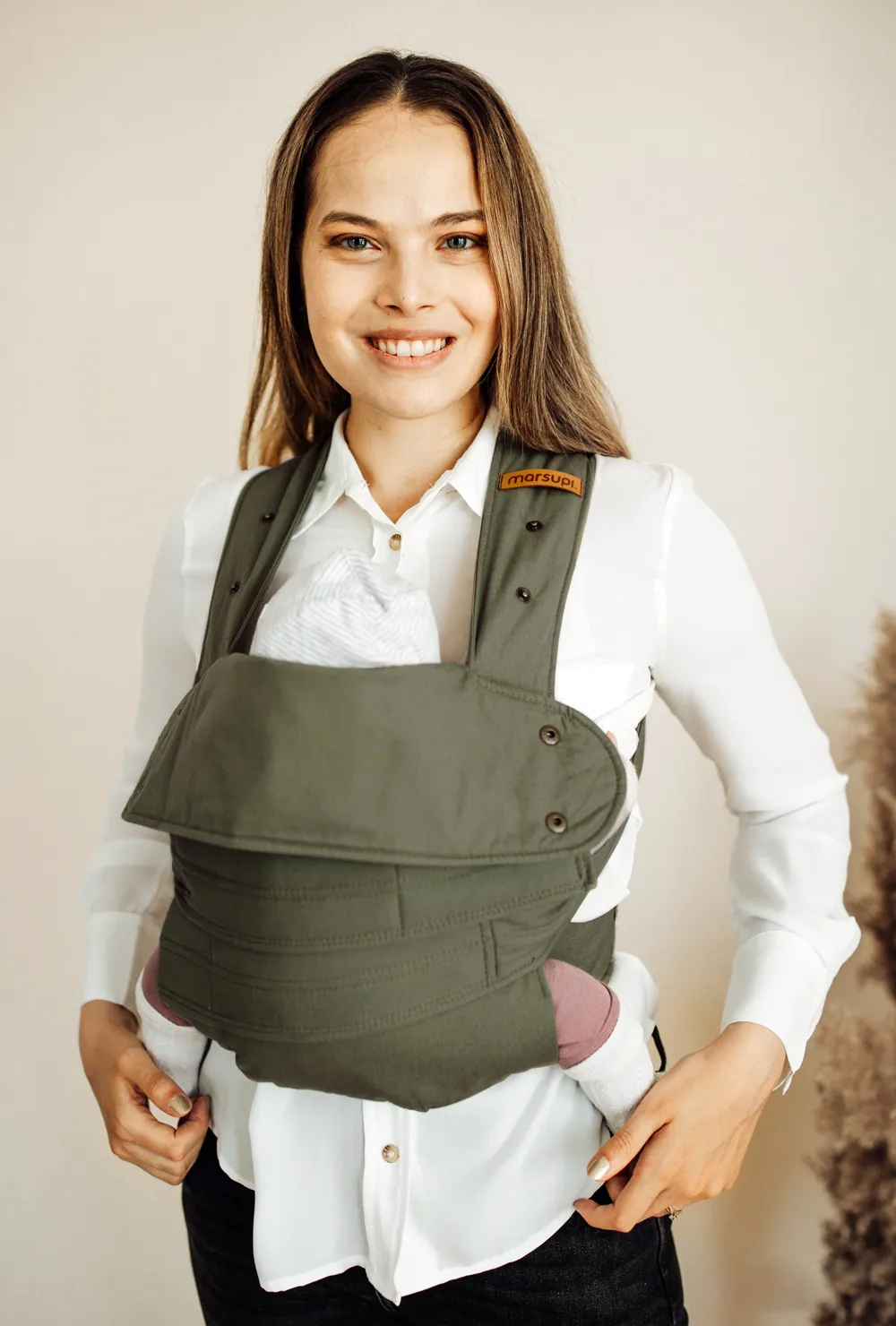 Frau trägt Baby in der Marsupi Classic 2 Babytrage Olivgrün (Olive), Frontansicht im Studio